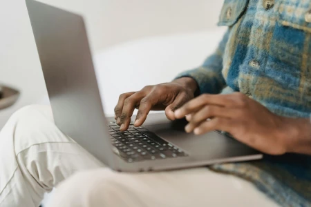 Male hands typing on a laptop.