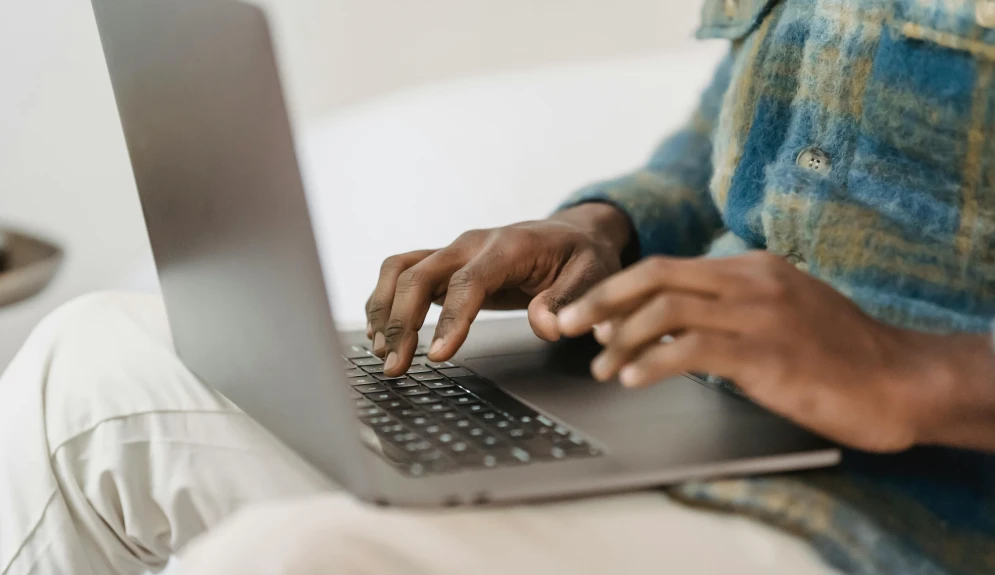 Male hands typing on a laptop.
